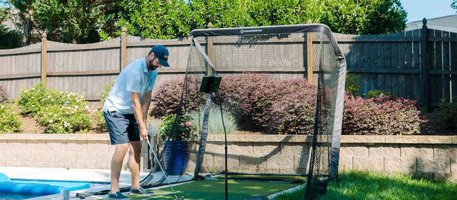 Golfer practicing into a net in the backyard this Father's Day