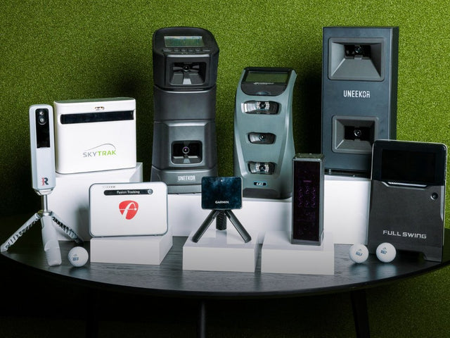 Golf launch monitors from every major brand lined up on a table