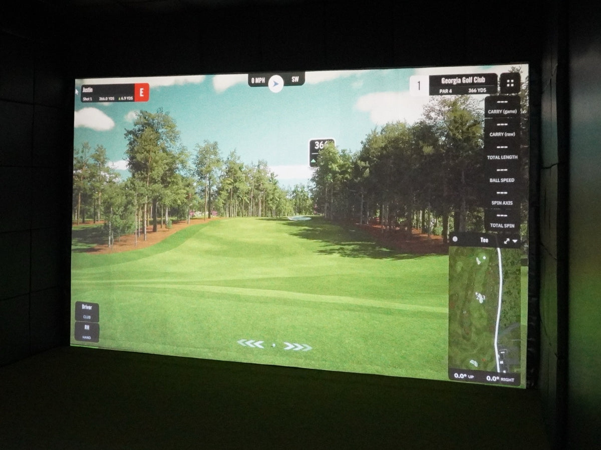 Golf simulator room with a wall-to-wall built-in impact screen showing a golf course