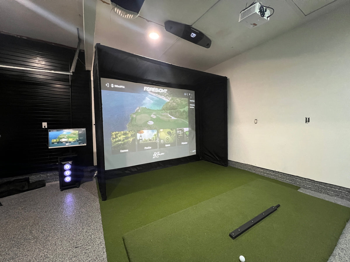 Garage golf simulator with a SwingBay enclosure, impact screen and turf